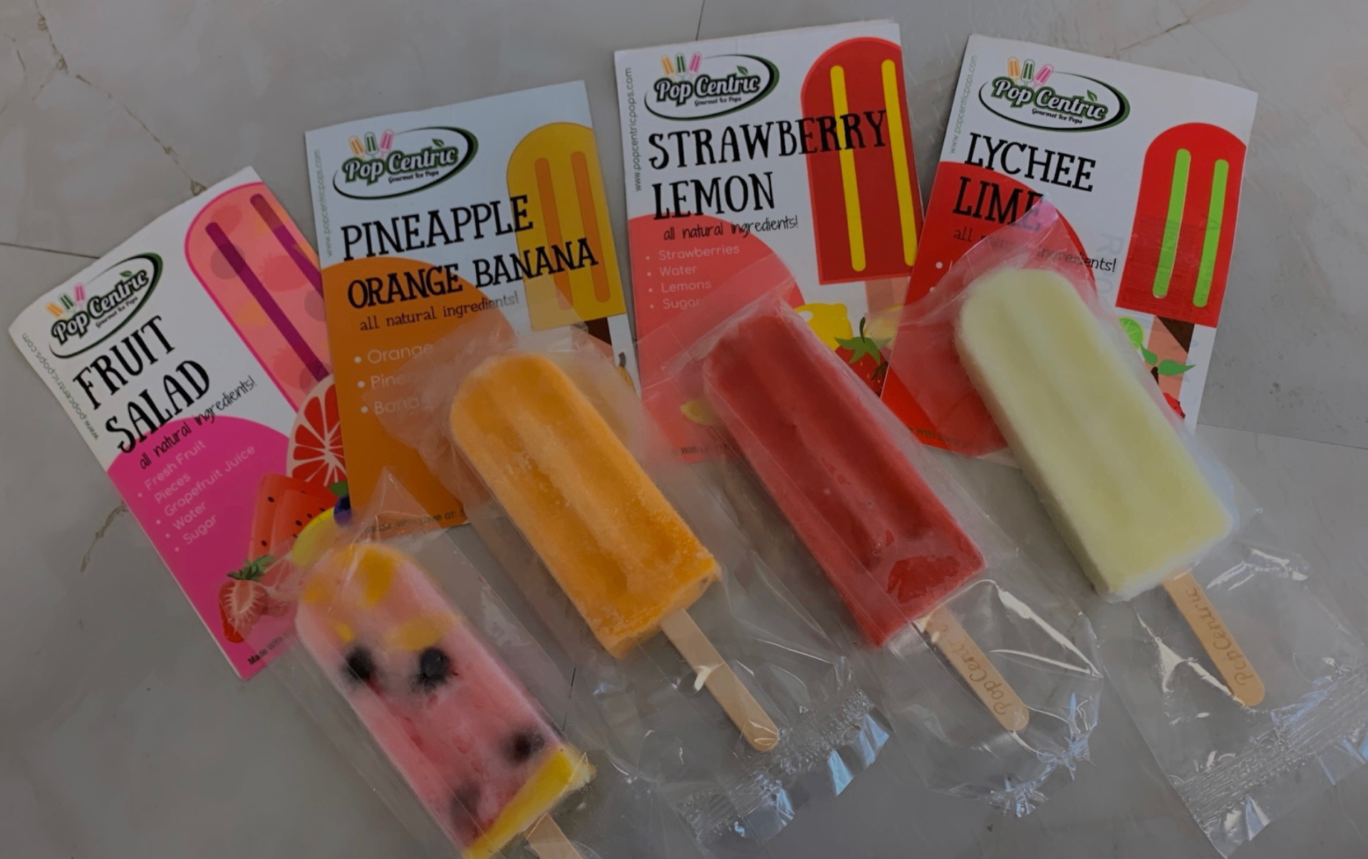 PopCentric flavor lineup: Fruit Salad, Pineapple Orange Banana, Strawberry Lemon, and Lychee Lime